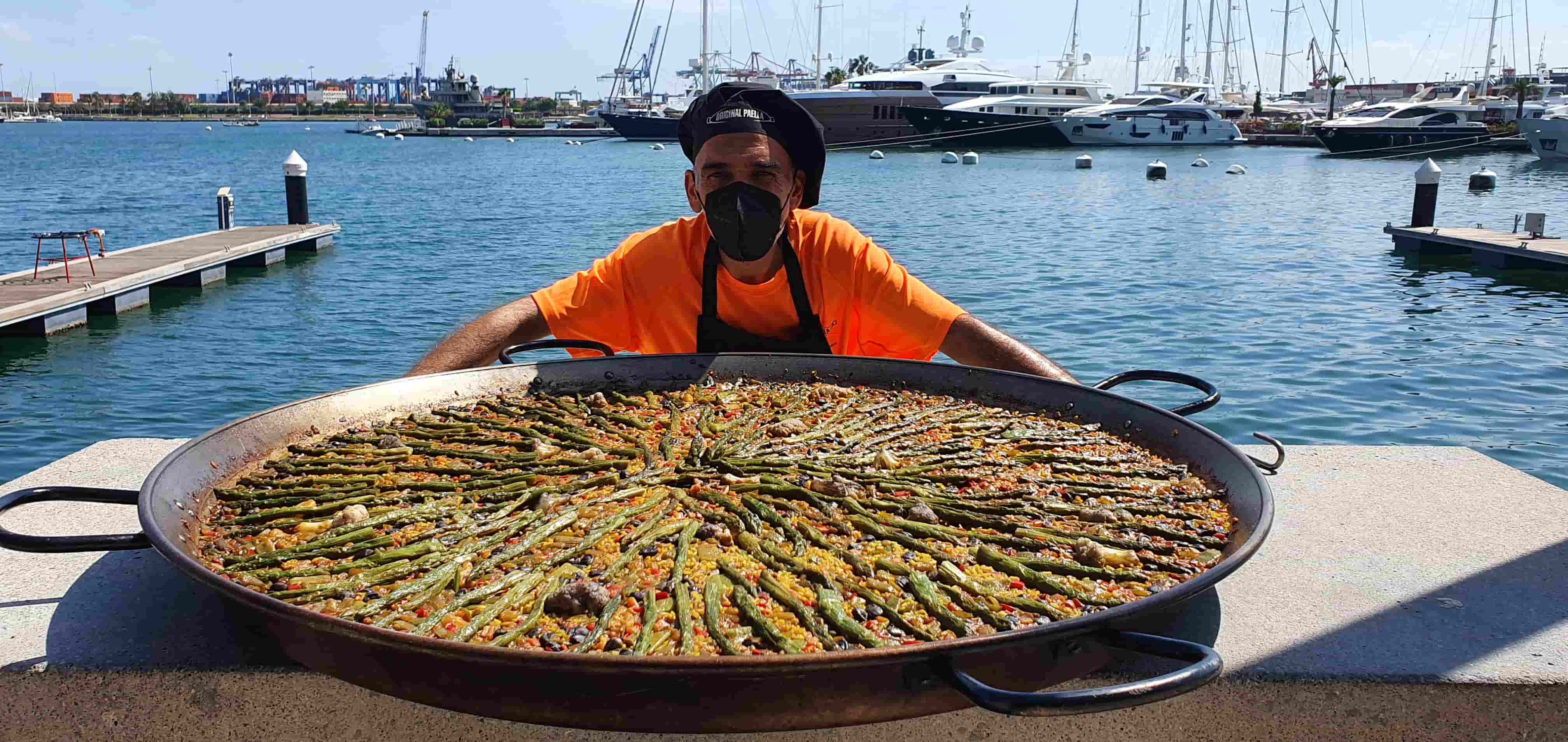 Maestro paellero de Original Paella con una paella gigante en el puerto de Valencia